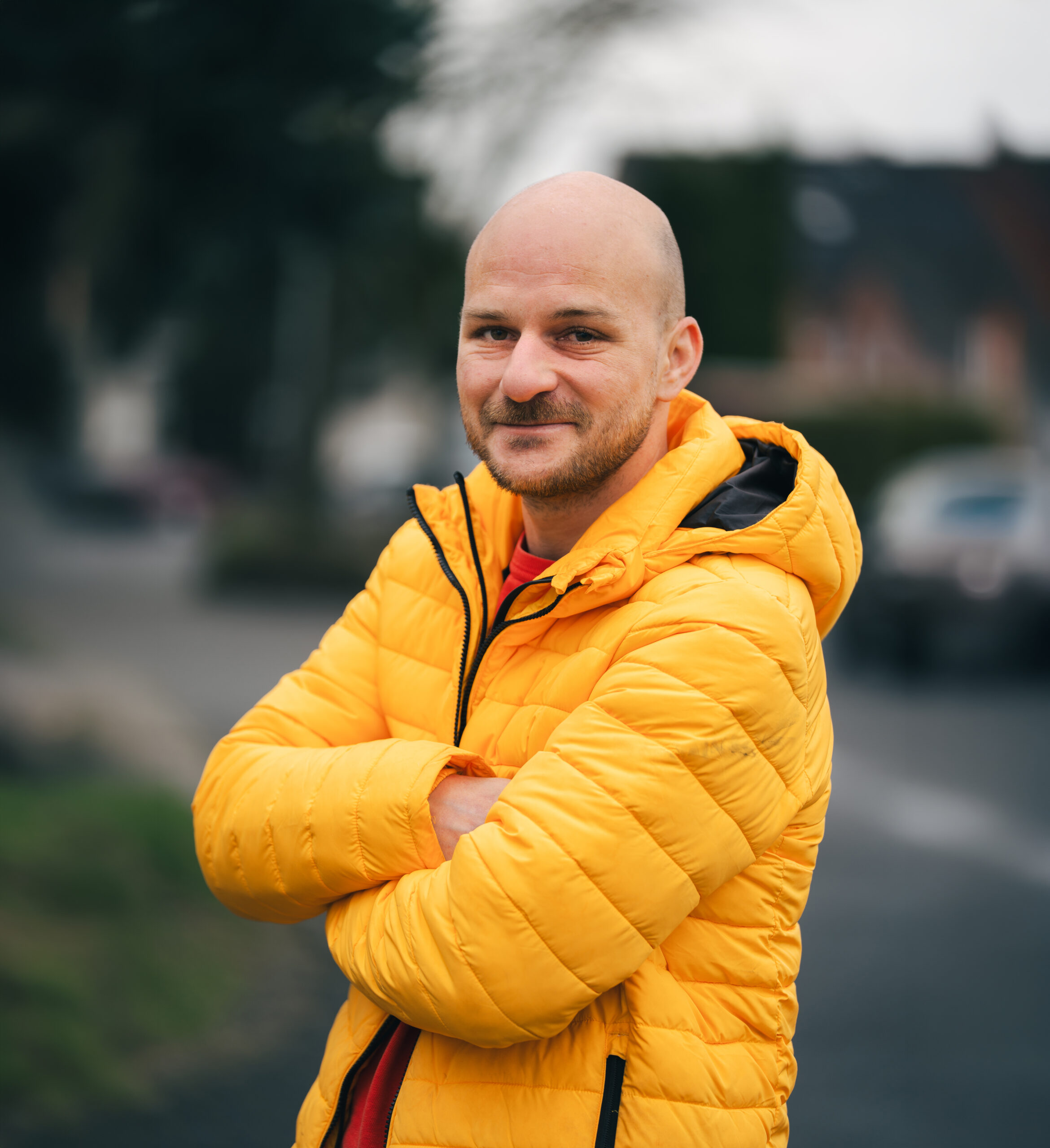 Mitarbeiter der MMS GmbH steht mit verschränkten Armen im Freien und blickt freundlich in die Kamera.